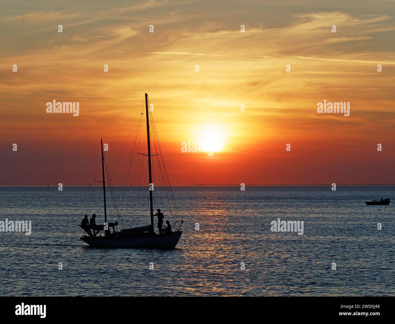 Vista di uno spettacolare tramonto rosso vivido con uno yacht in primo piano, visto da St Kilda Beach, Melbourne, Australia Foto Stock