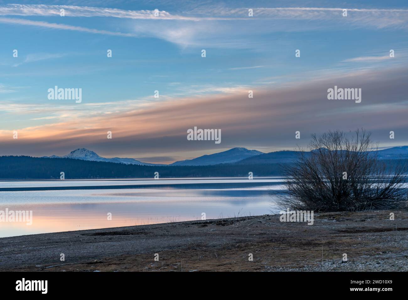 Immagine suggestiva del lago Almanor nelle montagne della California con acque fresche e calme in primo piano e il monte Lassen sullo sfondo. Foto Stock