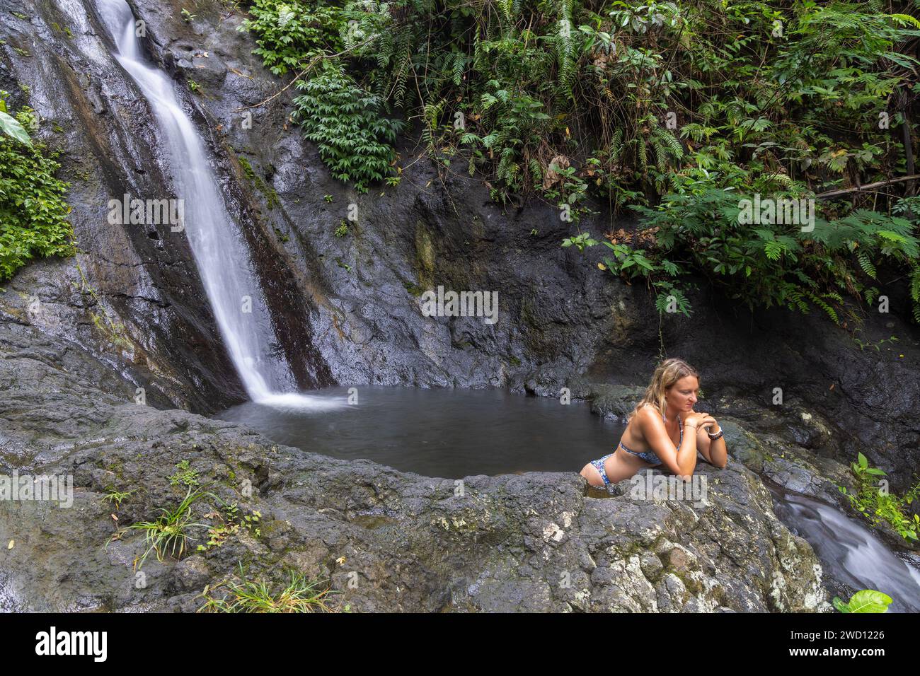 Una giovane donna alla cascata di Gembleng nell'isola di Bali, Indonesia Foto Stock