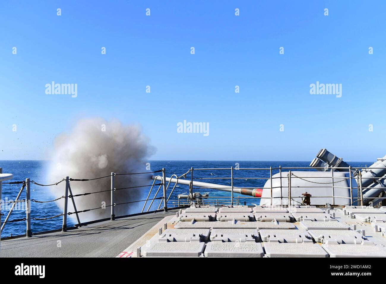 L'incrociatore missilistico guidato USS Hue City spara un cannone Mark 45 da 5 pollici. Foto Stock