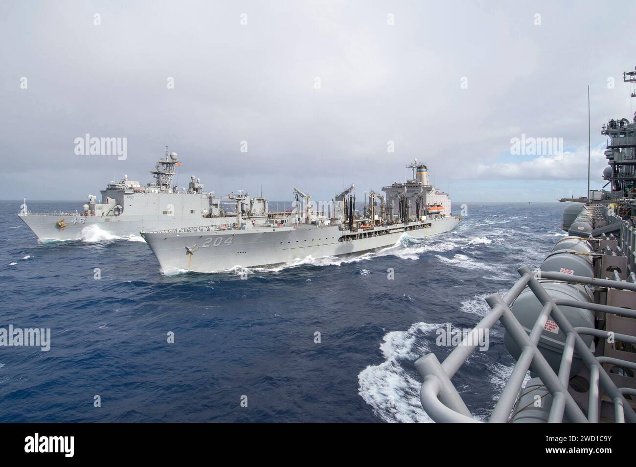 La USS Ashland e la USNS Rappahannock transitano accanto alla USS Bonhomme Richard. Foto Stock