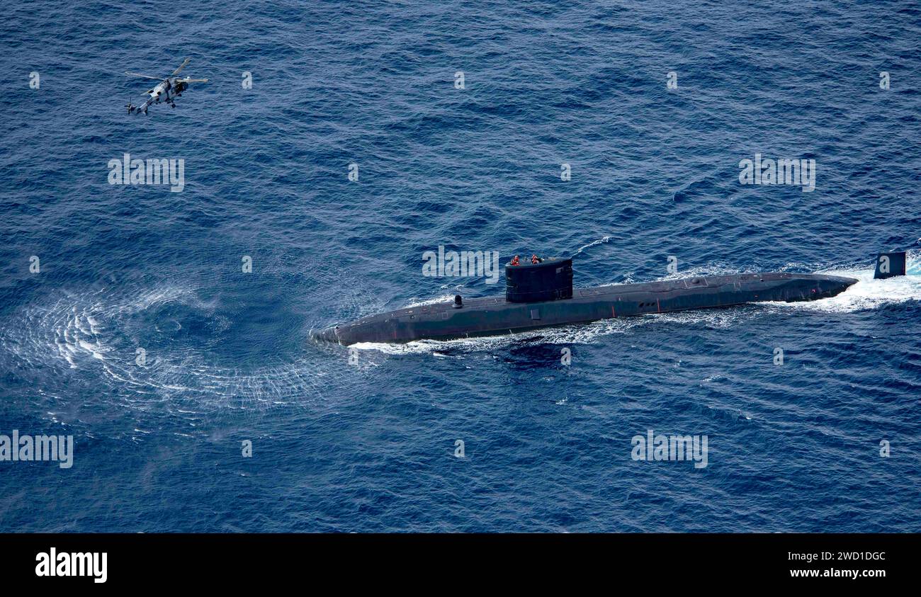 Sommergibile della Royal Navy HMS trenchant ed elicottero della Royal Navy Wildcat HMA2. Foto Stock