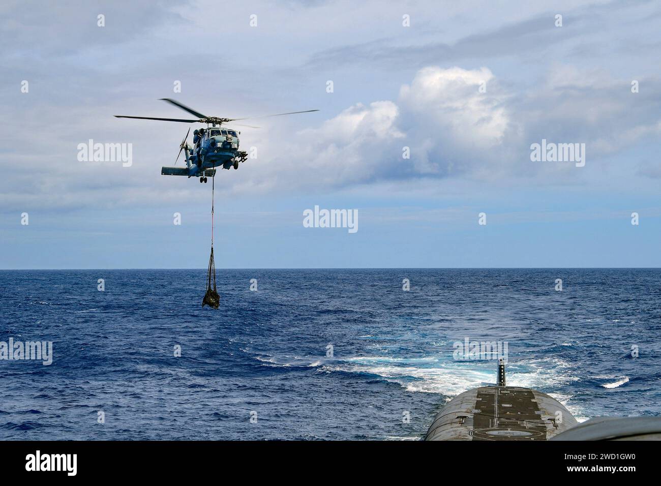 Un MH-60R Sea Hawk fornisce un carico utile al sottomarino missili balistici USS Henry M. Jackson. Foto Stock