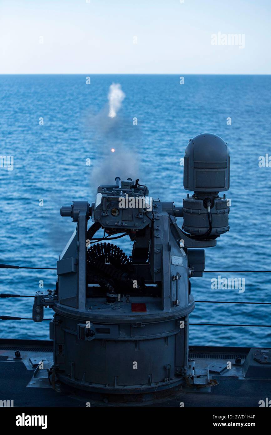 Il cacciatorpediniere guidato USS Sterett spara a distanza il suo cannone Mark da 38 25 mm nel Golfo dell'Oman. Foto Stock