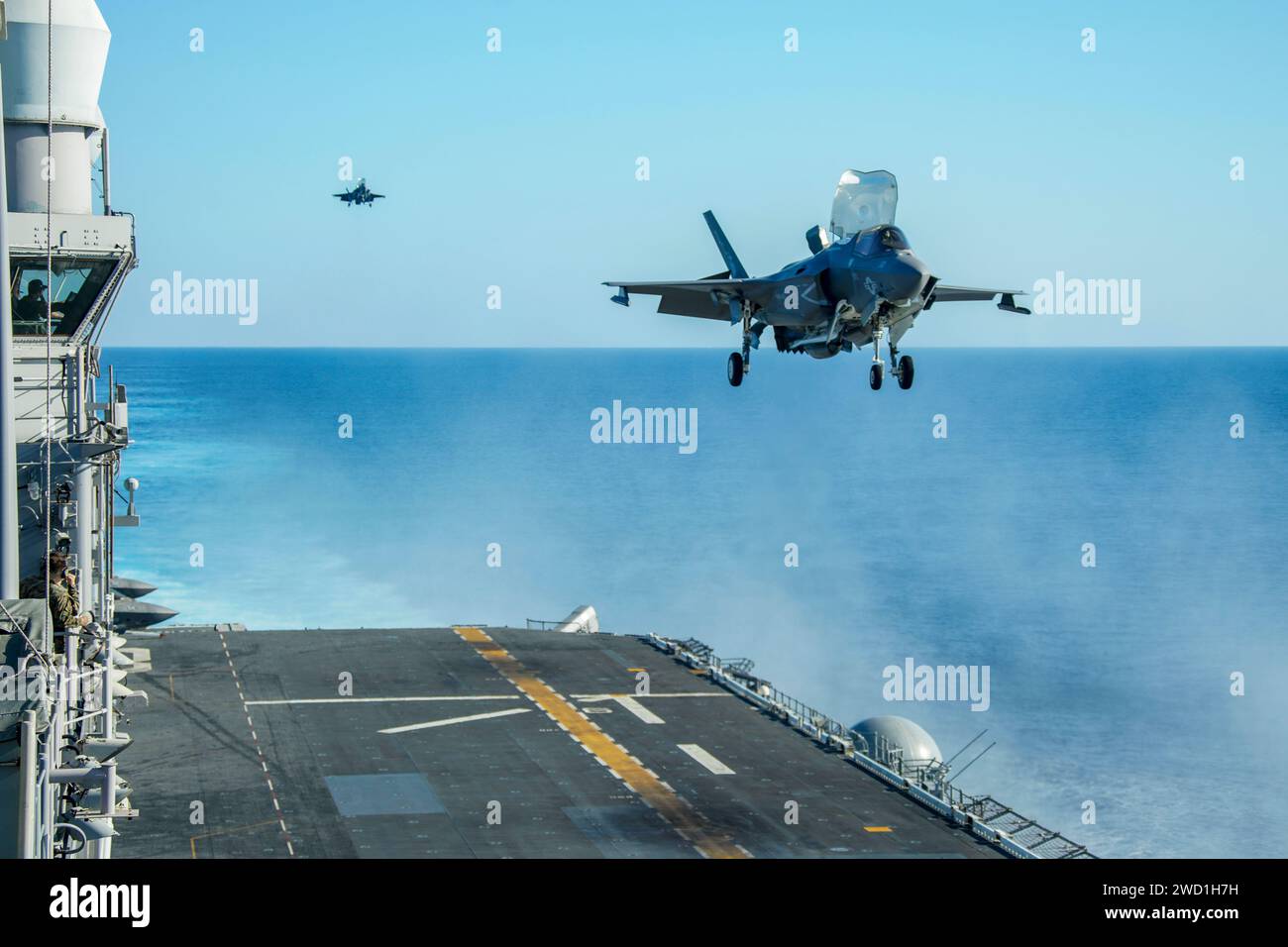 Gli F-35B Lightning II del corpo dei Marines degli Stati Uniti si preparano ad atterrare sul ponte di volo dell'isola USS Makin. Foto Stock