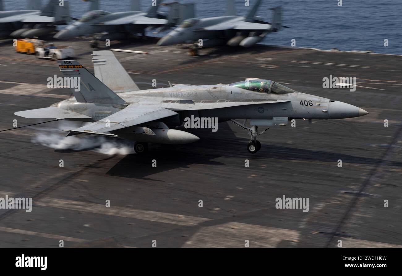 Un F/A-18C Hornet effettua un atterraggio arrestato sul ponte di volo della portaerei USS Nimitz. Foto Stock