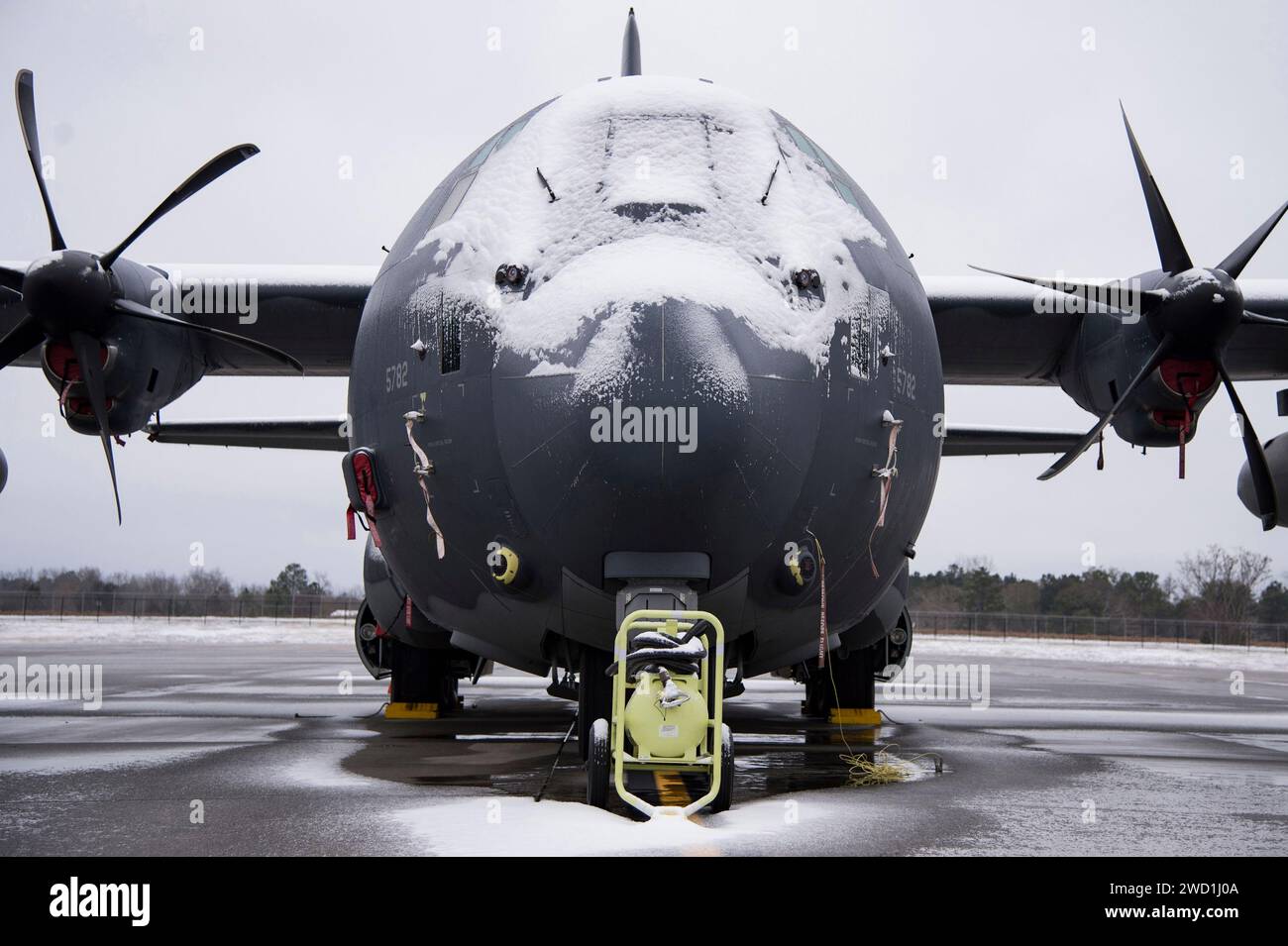 La neve copre un HC-130J Combat King II sulla linea di volo. Foto Stock