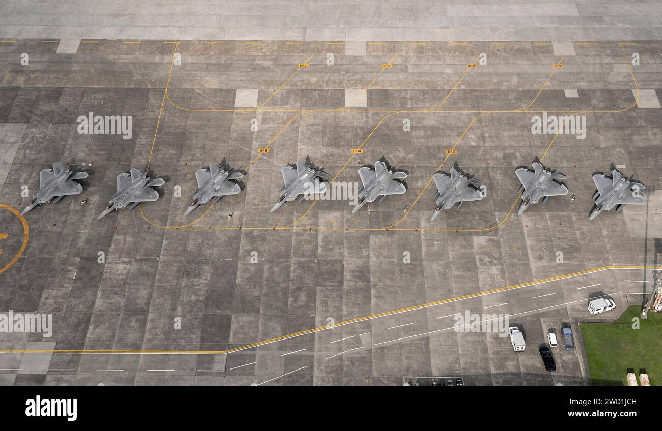 Otto F-22 Raptor dell'aeronautica militare statunitense si trovano sulla flightline presso la base aerea di Yokota, in Giappone. Foto Stock