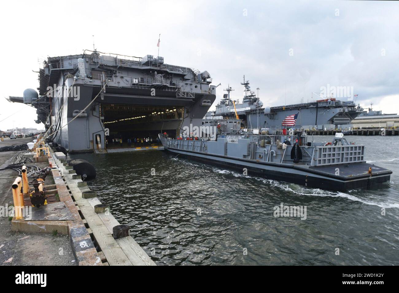 Landing Craft Utility conduce un matrimonio con la nave d'assalto anfibio USS Bataan. Foto Stock