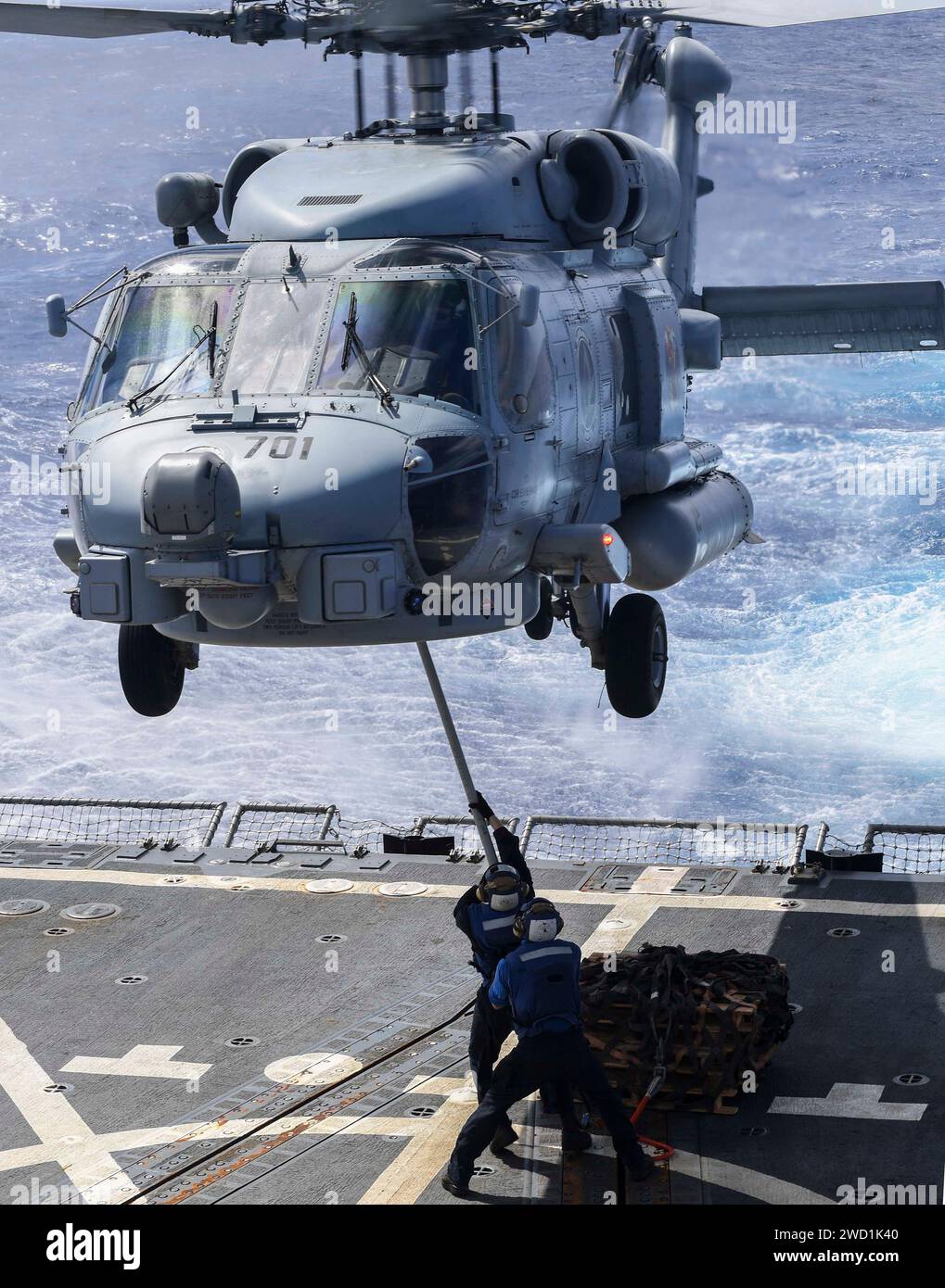 I marinai si esercitano ad attaccare pallet su un elicottero MH-60R Sea Hawk a bordo della USS Wayne E. Meyer. Foto Stock