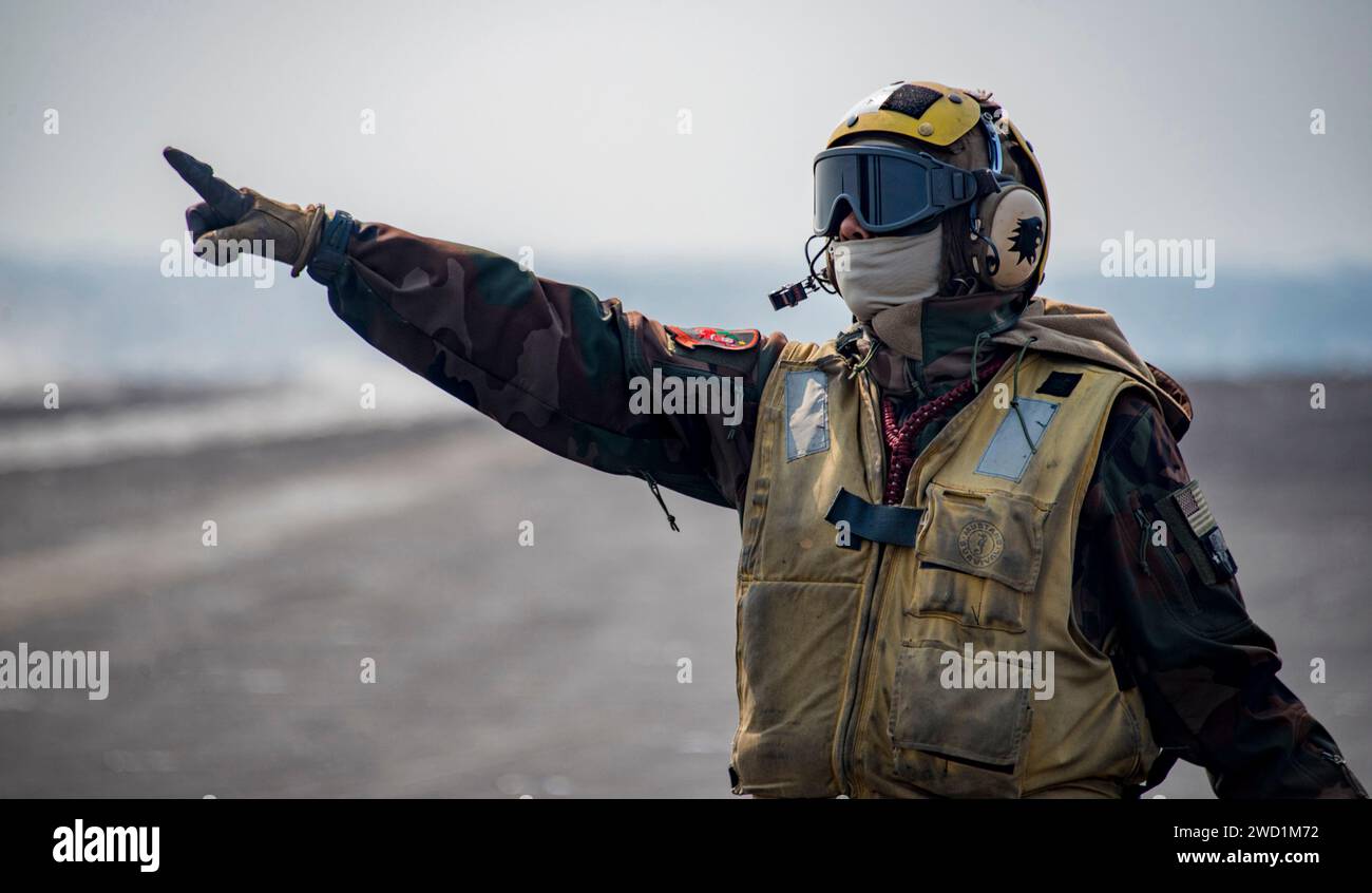 Aviation Boatswain's Mate dirige gli aerei sul ponte di volo della USS Carl Vinson. Foto Stock