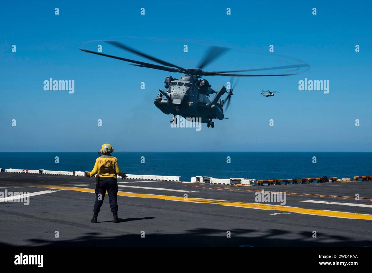 Il Mate di Aviation Boatswain segnala a un CH-53E Super Stallion di atterrare. Foto Stock