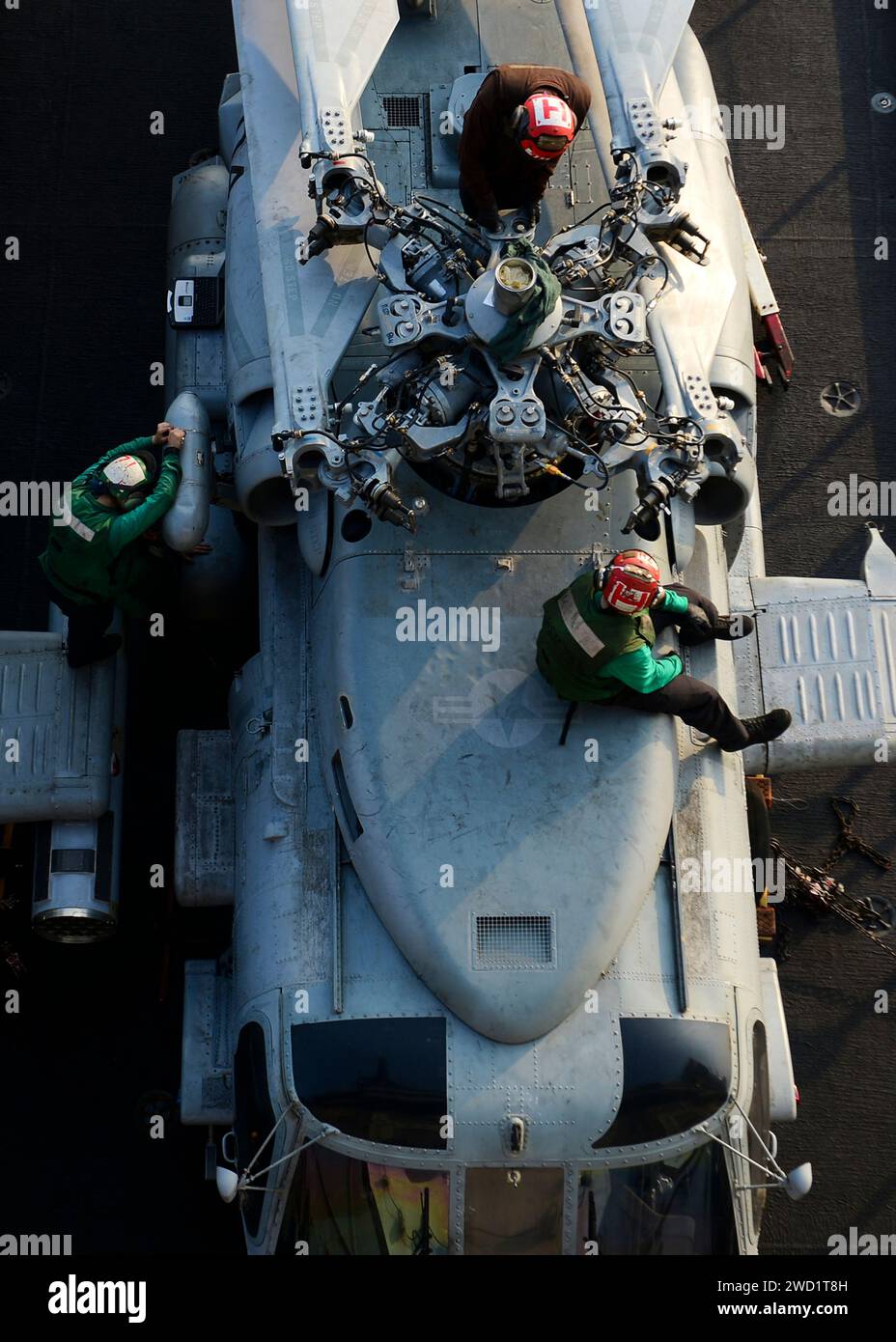 I marinai puliscono e lubrificano un complessivo rotore su un elicottero MH-60R Sea Hawk. Foto Stock