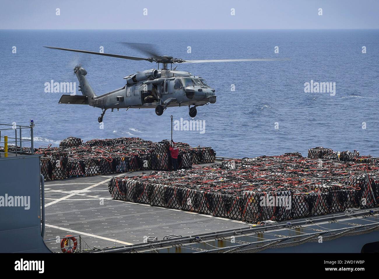Un elicottero MH-60S Sea Hawk trasporta merci dall'USNS Amelia Earhart durante un rifornimento in mare. Foto Stock