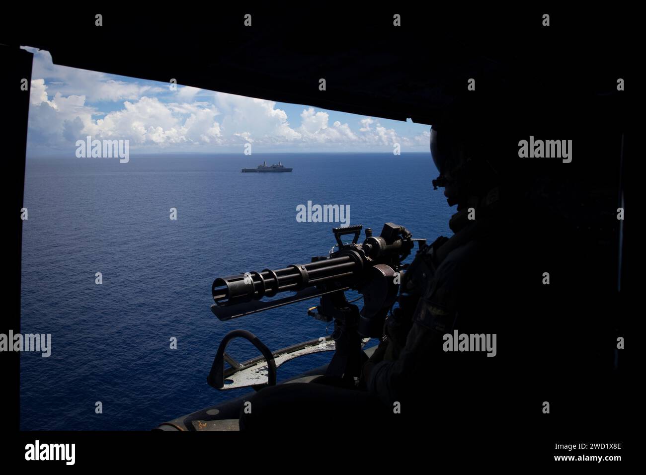 Un Marine americano guarda fuori dalla porta di un elicottero UH-1Y Huey alla USS New Orleans. Foto Stock