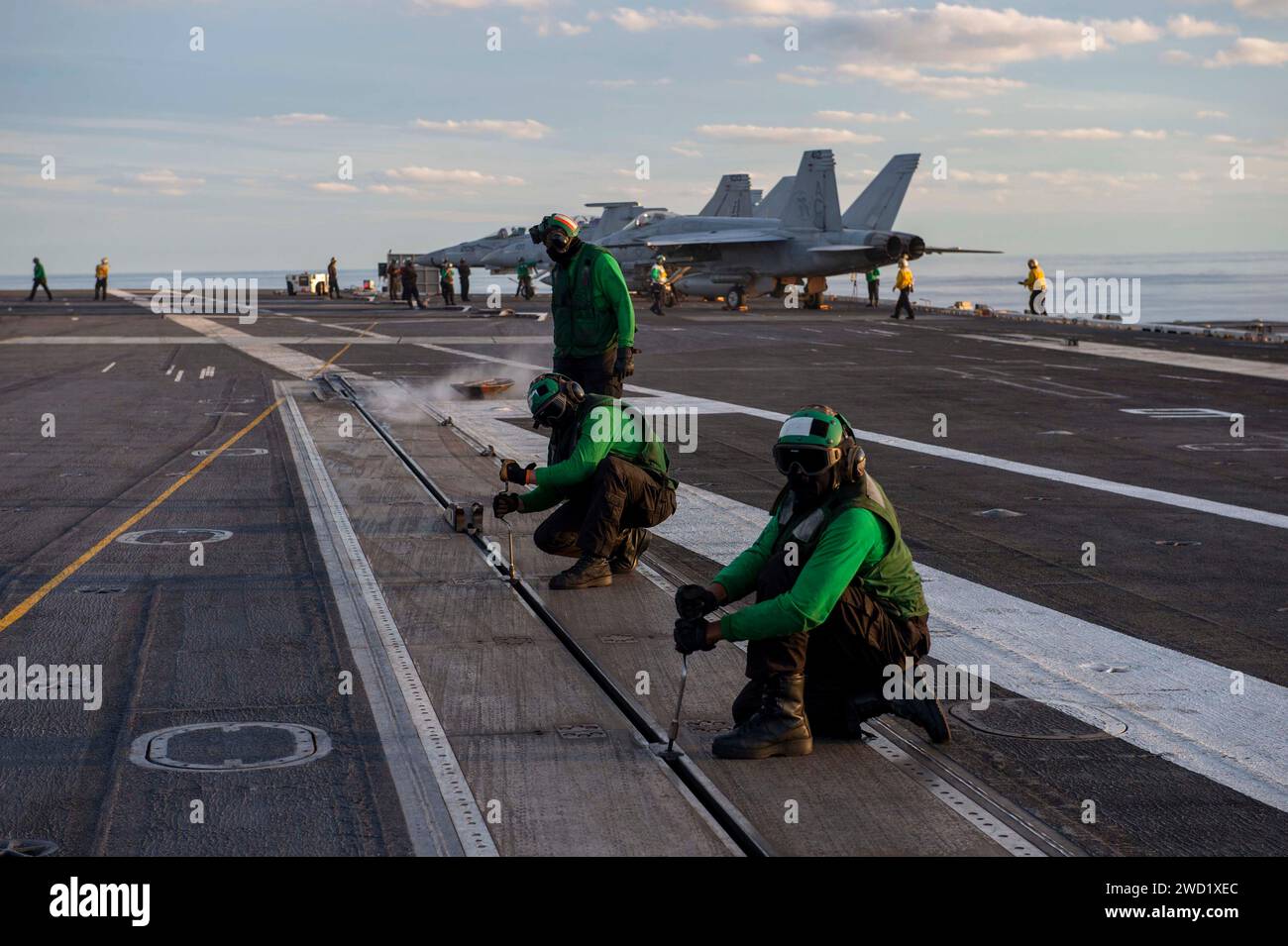 I marinai eseguono la manutenzione sul ponte di volo a bordo della USS Dwight D. Eisenhower. Foto Stock