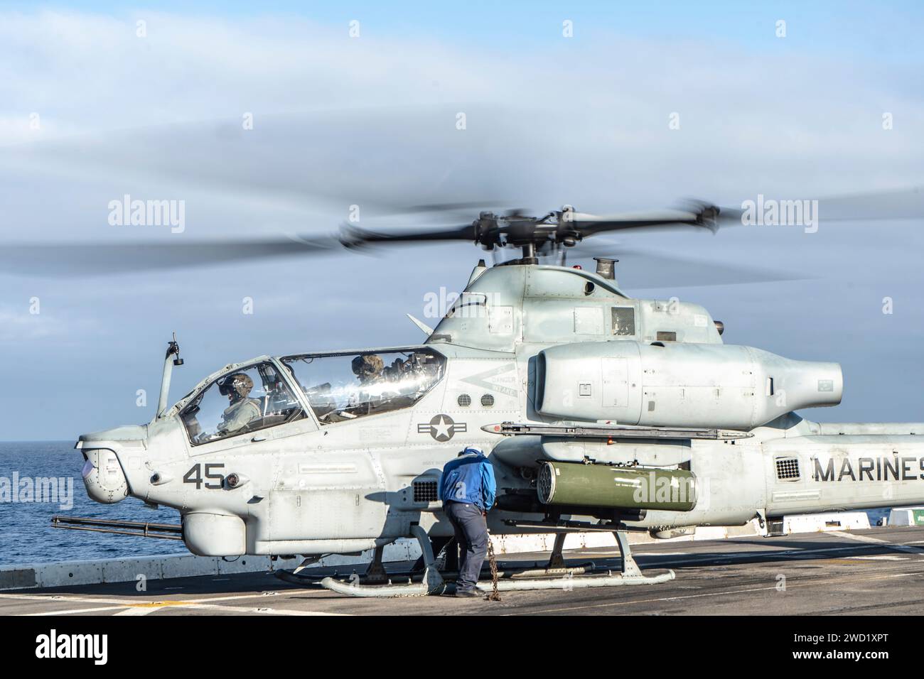 Marinaio a bordo della nave da trasporto anfibio USS Somerset rimuove le catene da un AH-1Z Viper. Foto Stock