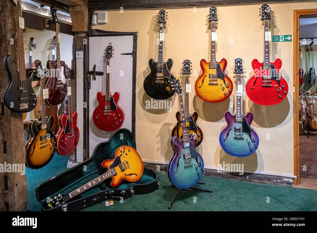 Negozio specializzato in Guitar Village che vende chitarre a Farnham, Surrey, Inghilterra, Regno Unito. Chitarre in mostra all'interno del negozio di musica. Foto Stock