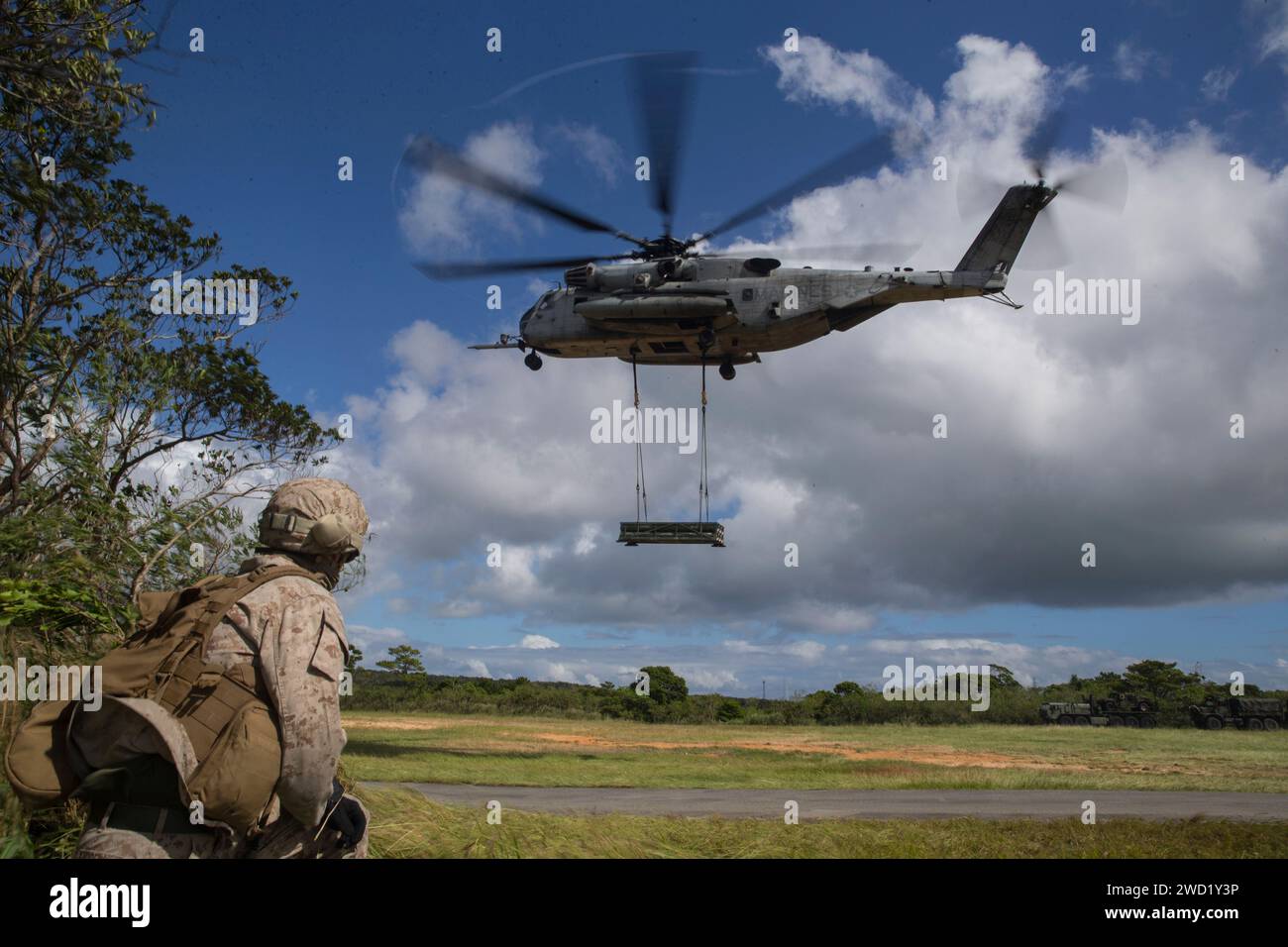 U.S. Marine assiste al decollo di uno stallone marino CH-53 con un sistema di razzi artiglieria ad alta mobilità. Foto Stock