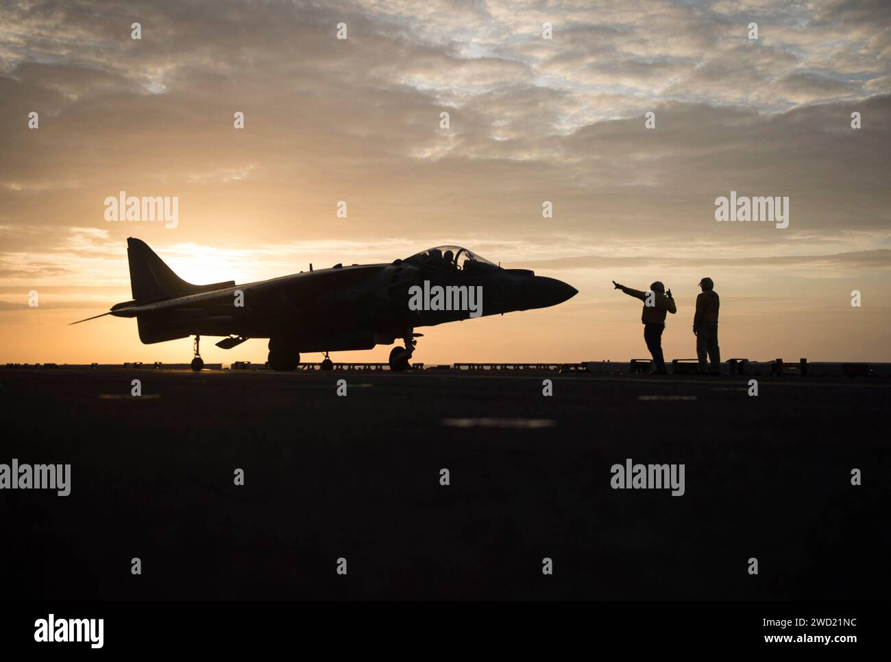 Aviation Boatswain's Mates dirige il movimento di un AV-8B Harrier mentre si prepara per il lancio. Foto Stock