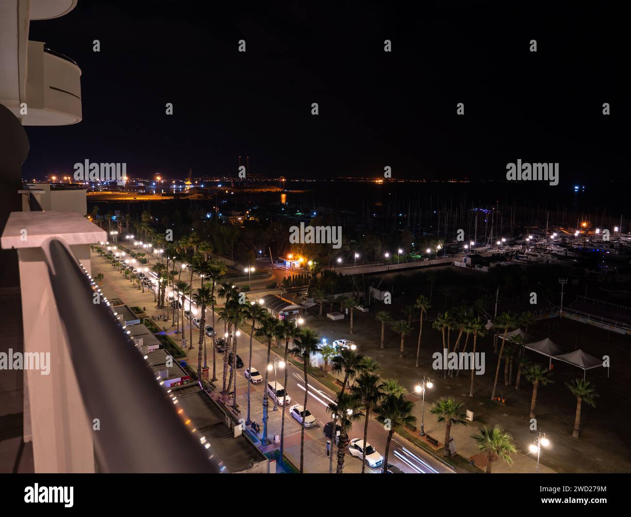 Vista aerea sulla passerella notturna delle palme Finikoudes e sul molo con yacht vicino al Mar Mediterraneo a Larnaca, Cipro. Paesaggio urbano industriale. Foto Stock