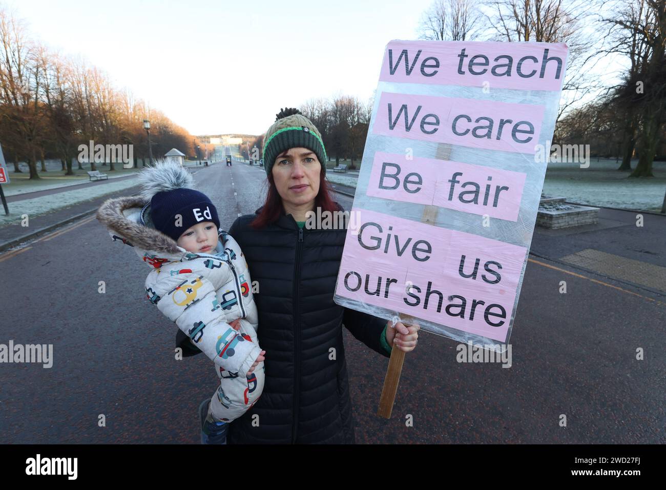 Membro dell'Ulster Teachers Union e insegnante alla Ballyclare Secondary School, Linda Millar, con suo figlio ed sulla linea del picchetto fuori dai cancelli della tenuta di Stormont, con una stima di 150.000 lavoratori che prendono parte a passaggi di salario in tutta l'Irlanda del Nord. Lo sciopero avrà un grande impatto con le scuole chiuse, gli ospedali che offrono solo servizi a livello di Natale, i trasporti pubblici annullati e il limitato grattamento delle strade a temperature zero. Data foto: Giovedì 18 gennaio 2024. Foto Stock