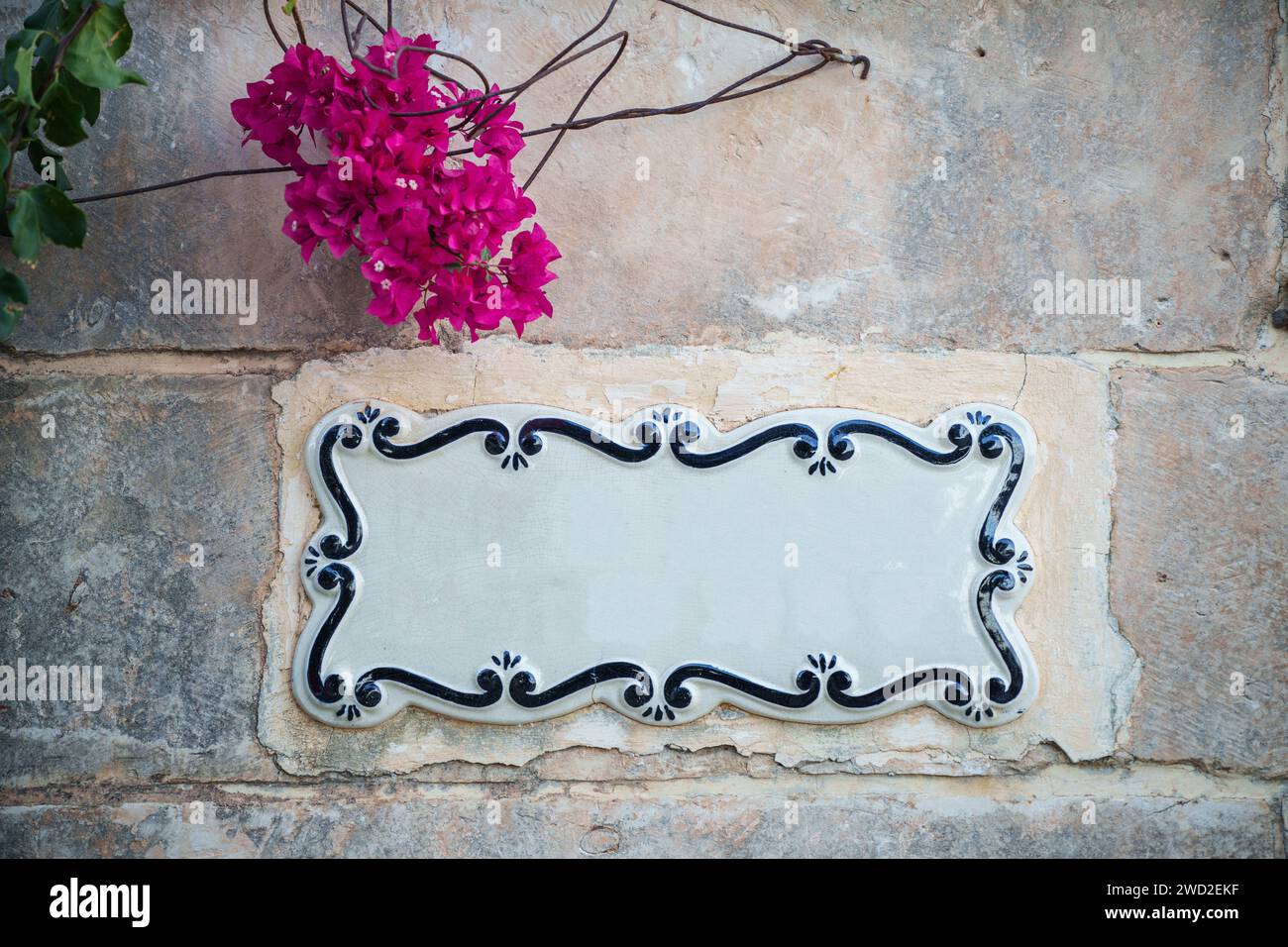 Cartellonistica tradizionale maltese dipinta su piastrelle di ceramica collocate sulla parete di pietra senza testo all'interno. Foto Stock