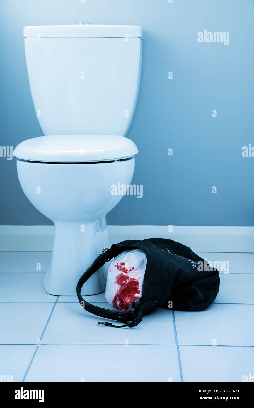 Camicia macchiata di sangue in un sacchetto vicino a una toilette. Foto Stock