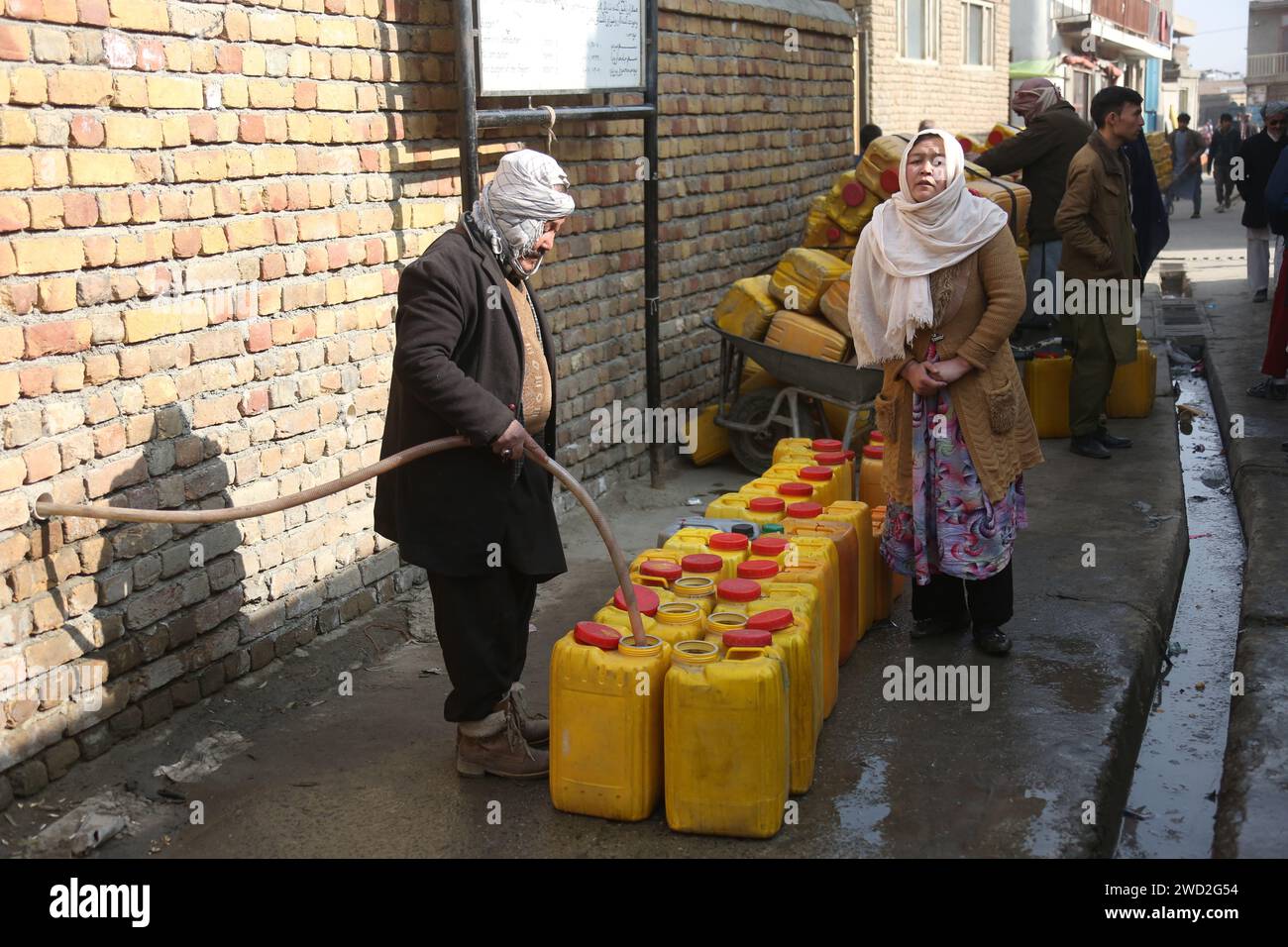 Kabul, Afghanistan. 11 gennaio 2024. Un uomo riempie i barili di acqua a Kabul, capitale dell'Afghanistan, 11 gennaio 2024. PER ANDARE CON 'caratteristica: I residenti di Kabul colpiti dalla siccità che fanno la fila per ore per prendere l'acqua' credito: Saifurahman Safi/Xinhua/Alamy Live News Foto Stock