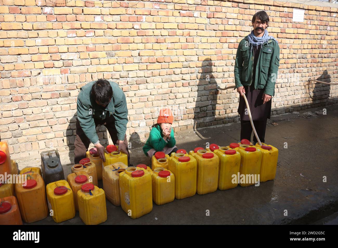 Kabul, Afghanistan. 11 gennaio 2024. Un uomo riempie i barili di acqua a Kabul, capitale dell'Afghanistan, 11 gennaio 2024. PER ANDARE CON 'caratteristica: I residenti di Kabul colpiti dalla siccità che fanno la fila per ore per prendere l'acqua' credito: Saifurahman Safi/Xinhua/Alamy Live News Foto Stock