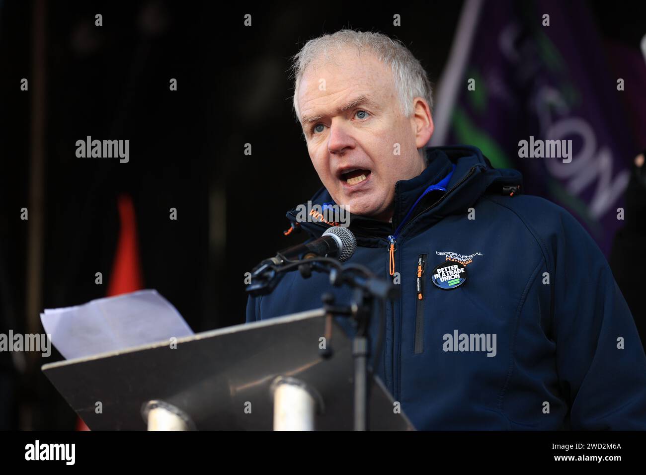 Justin McCamphill, funzionario nazionale NASUWT dell'Irlanda del Nord, si rivolge ai membri del sindacato sulla linea di picchetto fuori Belfast City Hall, Belfast, in quanto si stima che 150.000 lavoratori prendano parte a walkout sulla paga in tutta l'Irlanda del Nord. Lo sciopero avrà un grande impatto con le scuole chiuse, gli ospedali che offrono solo servizi a livello di Natale, i trasporti pubblici annullati e il limitato grattamento delle strade a temperature zero. Data foto: Giovedì 18 gennaio 2024. Foto Stock