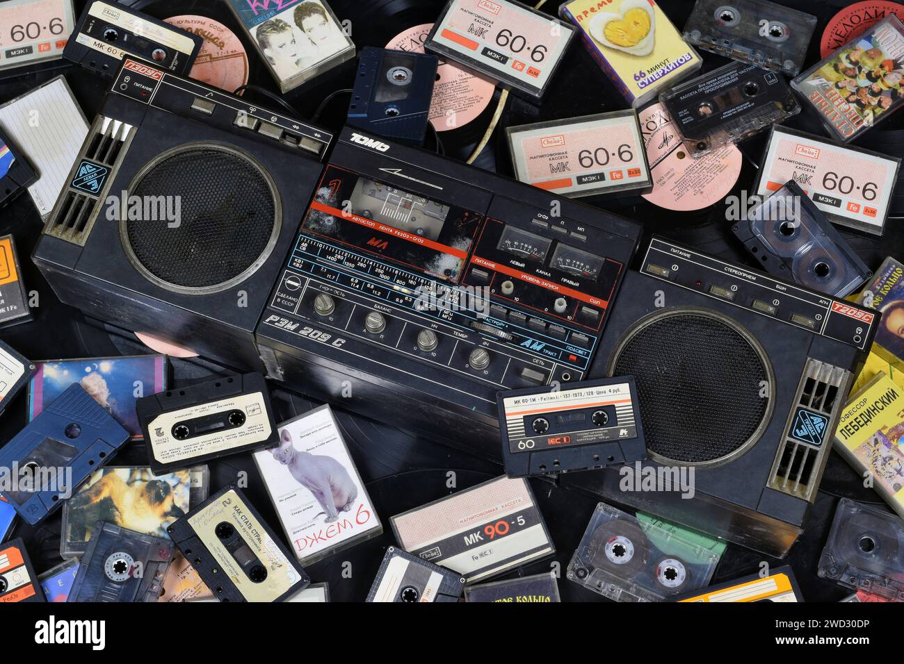 KIEV, UCRAINA - 4 MAGGIO 2023: Cassette audio impilate e posizionate intorno a un lettore di dischi obsoleto. Ricordo di un tempo passato Foto Stock