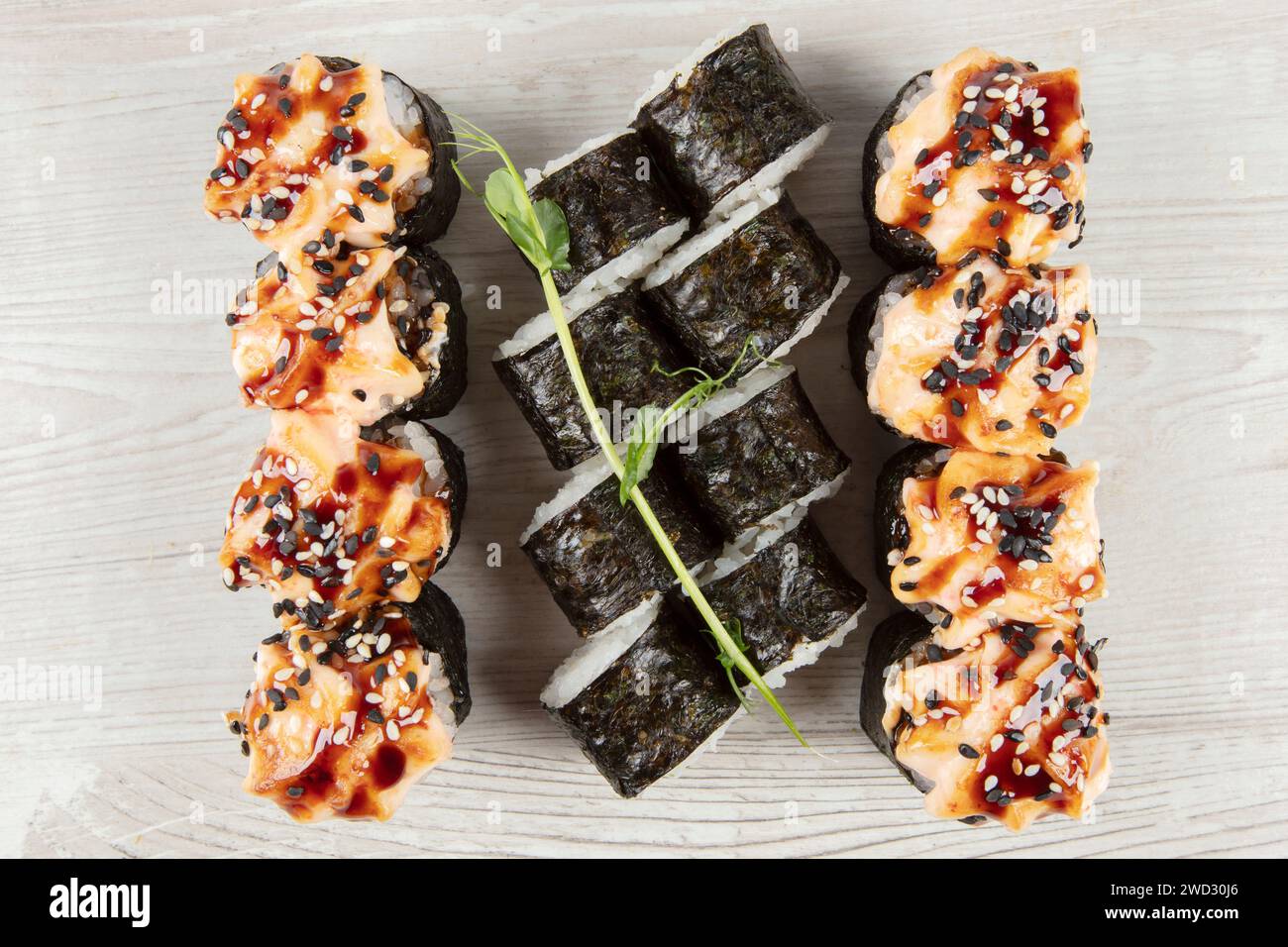Set di vari panini di sushi su uno sfondo di legno bianco. Cibo giapponese. Foto Stock