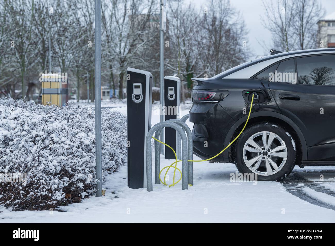 Un'auto elettrica alla stazione di ricarica in inverno Foto Stock