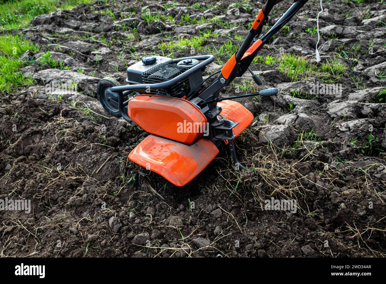 la marcia costante del progresso è incarnata nell'utilizzo da parte dell'agricoltore di un coltivatore, dando forma alla terra per la promessa di un raccolto abbondante. Foto Stock