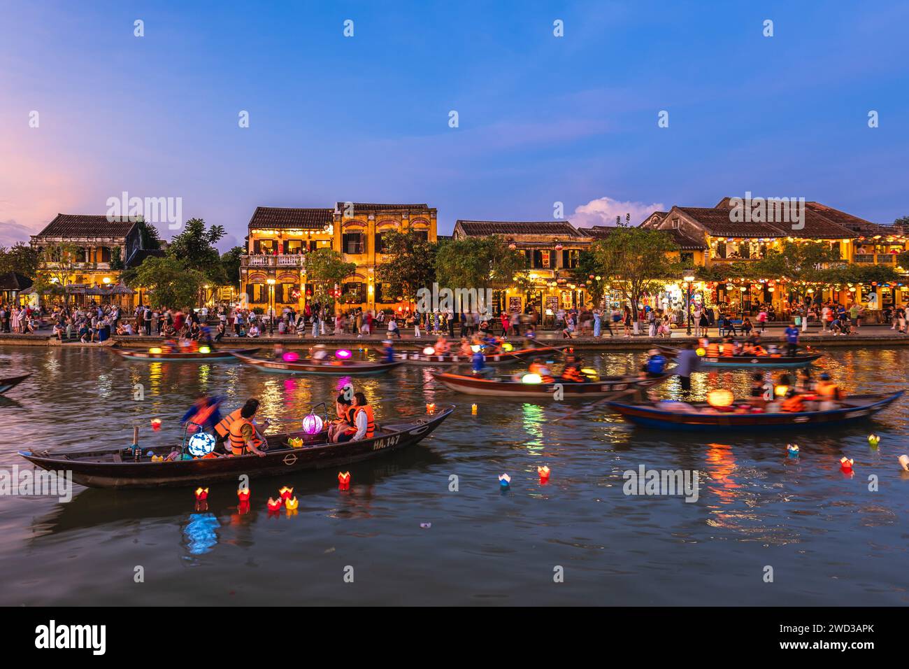 14 gennaio 2024: La gente cavalca le barche e rilascia lanterne di fiori di carta al fiume Thu Bon nell'antica città di Hoi An, in Vietnam di notte per pregare per la Be Foto Stock