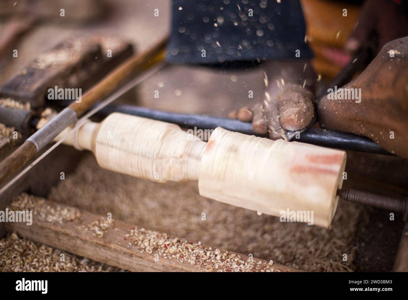 Un abile artigiano taglia meticolosamente il legno con una sega, trasformando il legno grezzo in belle opere d'arte e artigianato. Foto Stock