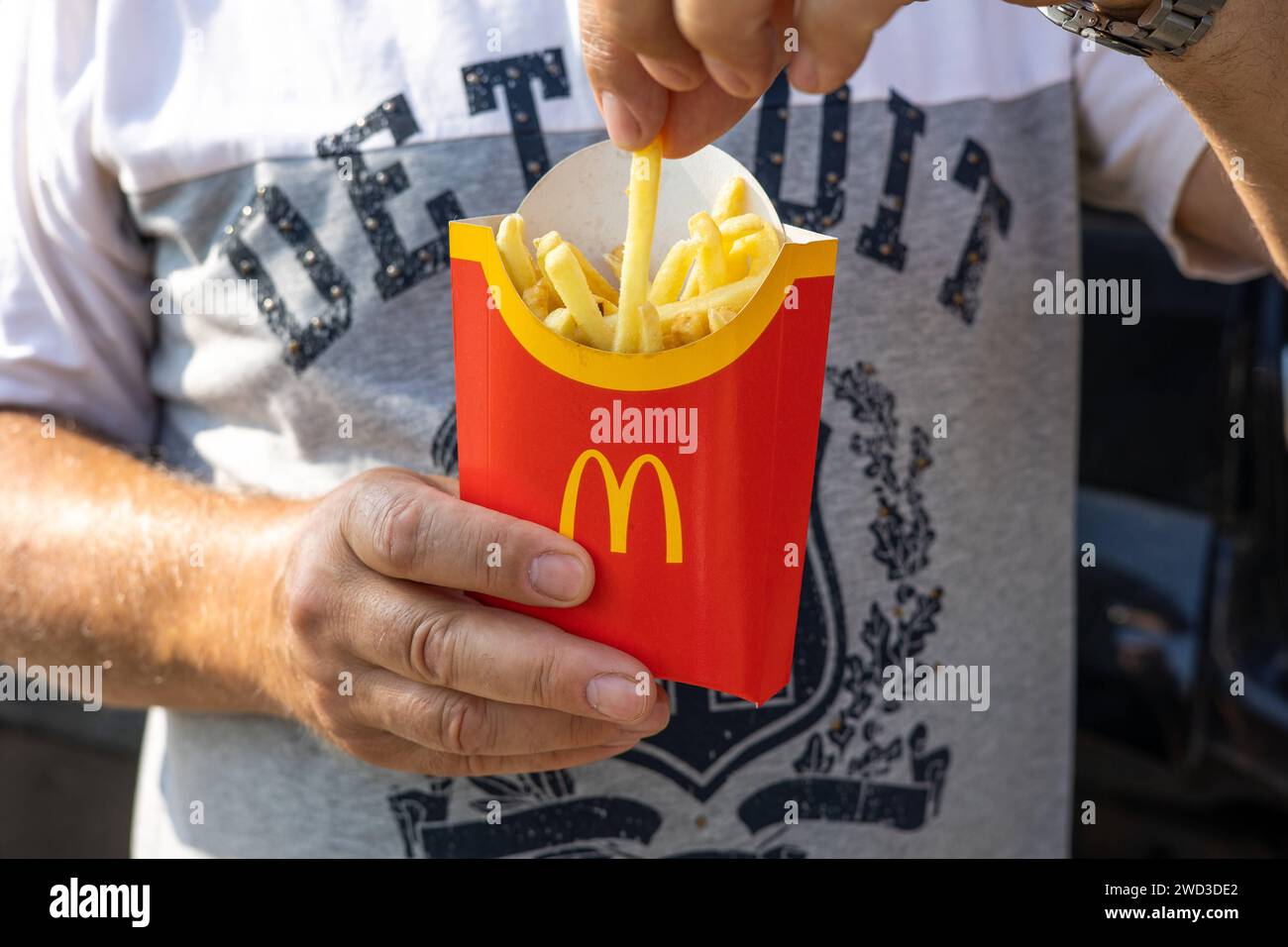 Quell'uomo ha in mano un sacchetto di carta pieno di patatine fritte del McDonalds. Il concetto di fast food e piatti da asporto. Kiev, Ucraina, 08 luglio 2023 Copyright: XDmytroxNikolaienkox Foto Stock