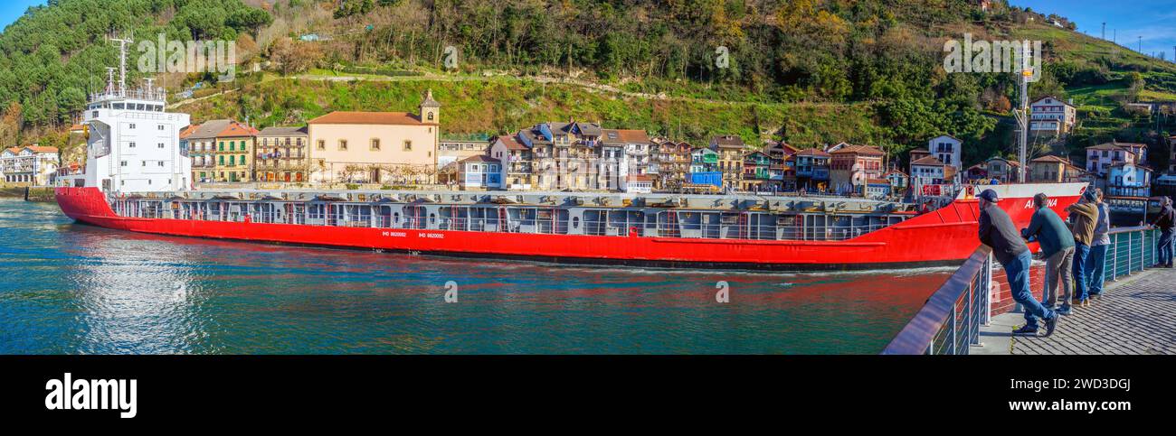 Una petroliera che attraversa di fronte al villaggio di pescatori di Pasajes de San Juan. Gipuzkoa, Paesi Baschi, Spagna. Foto Stock