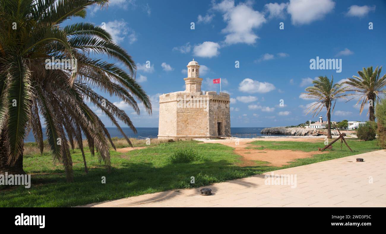 Ciutadella, Minorca, Isole Baleari, Spagna. Vista sul lungomare del Castell de Sant Nicolau, palma in primo piano. Foto Stock