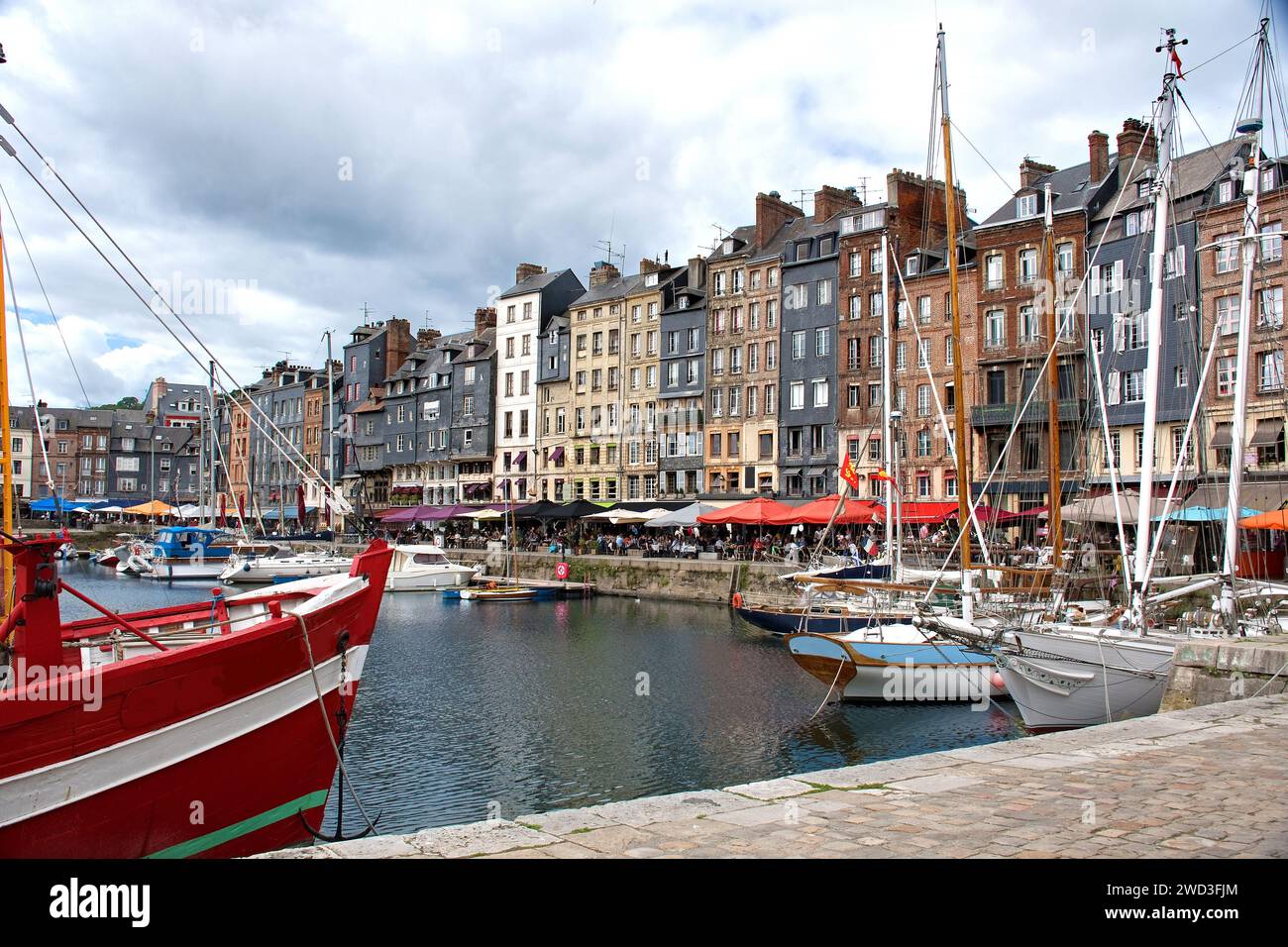 Honfleur, bacino del porto con case a graticcio e barche da pesca Foto Stock