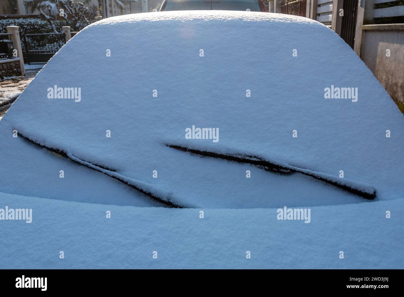 Primo piano del parabrezza di un'auto coperta da uno strato di neve sulla strada in una fredda mattinata invernale Foto Stock