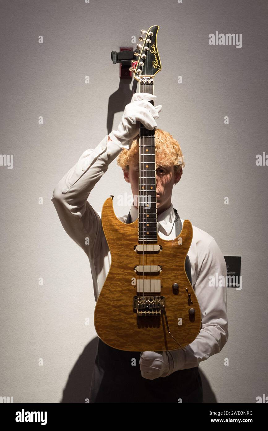 LONDRA, REGNO UNITO - 18 GENNAIO 2023: Un membro dello staff detiene pensa-Suhr, New York, 1988, una chitarra elettrica a corpo solido, MK-1, stima: 6.000-8.000£ che è stato utilizzato al concerto Nelson Mandela 70th Birthday Tribute l'11 giugno 1988 al Wembley Stadium durante una foto alla casa d'aste di Christie che mostra i momenti salienti della collezione personale di Mark Knopfler, frontman dell'iconica band britannica, i dire Straits, a Londra, Regno Unito il 18 gennaio 2023. Le chitarre saranno offerte all'asta il 31 gennaio e il 25% del prezzo totale del martello sarà devoluto ai Red Cros britannici Foto Stock