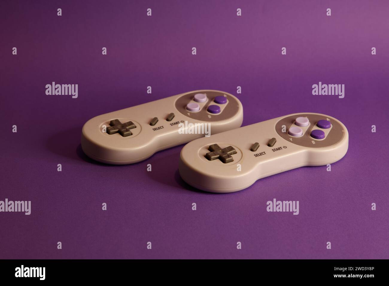 Console per videogiochi di tipo Nintendo su sfondo mouve, fotografia in studio Foto Stock