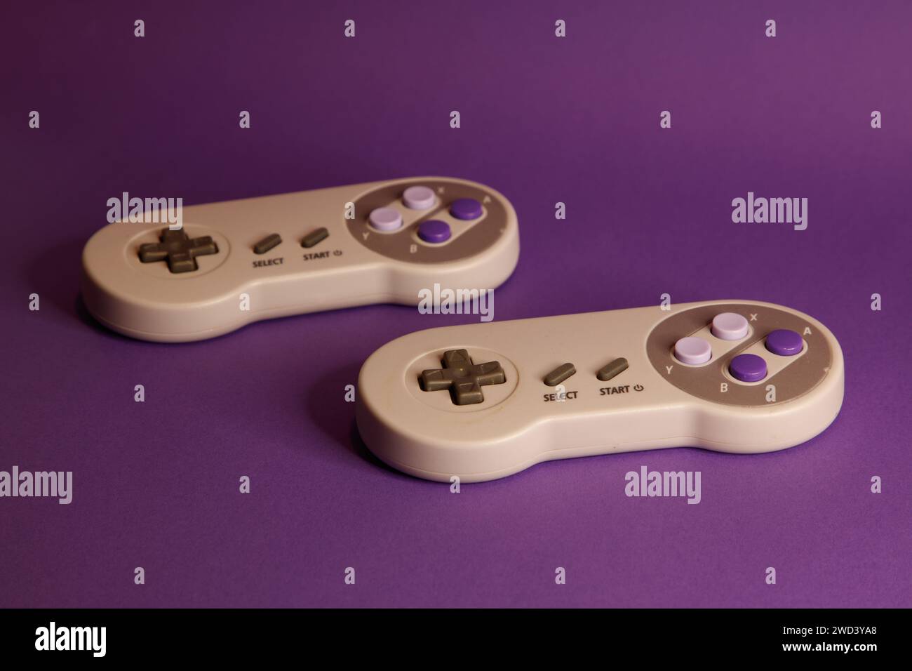 Console per videogiochi di tipo Nintendo su sfondo mouve, fotografia in studio Foto Stock