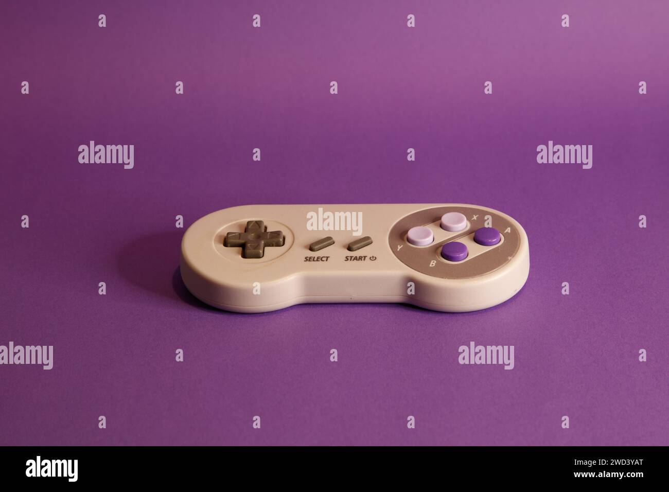 Console per videogiochi di tipo Nintendo su sfondo mouve, fotografia in studio Foto Stock