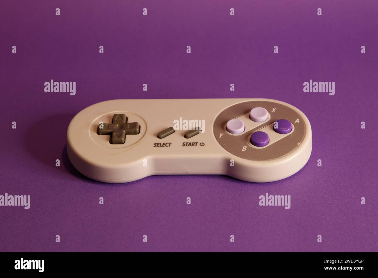 Console per videogiochi di tipo Nintendo su sfondo mouve, fotografia in studio Foto Stock