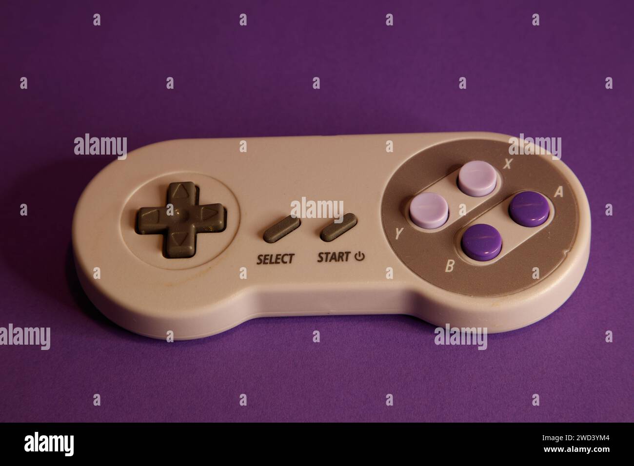 Console per videogiochi di tipo Nintendo su sfondo mouve, fotografia in studio Foto Stock