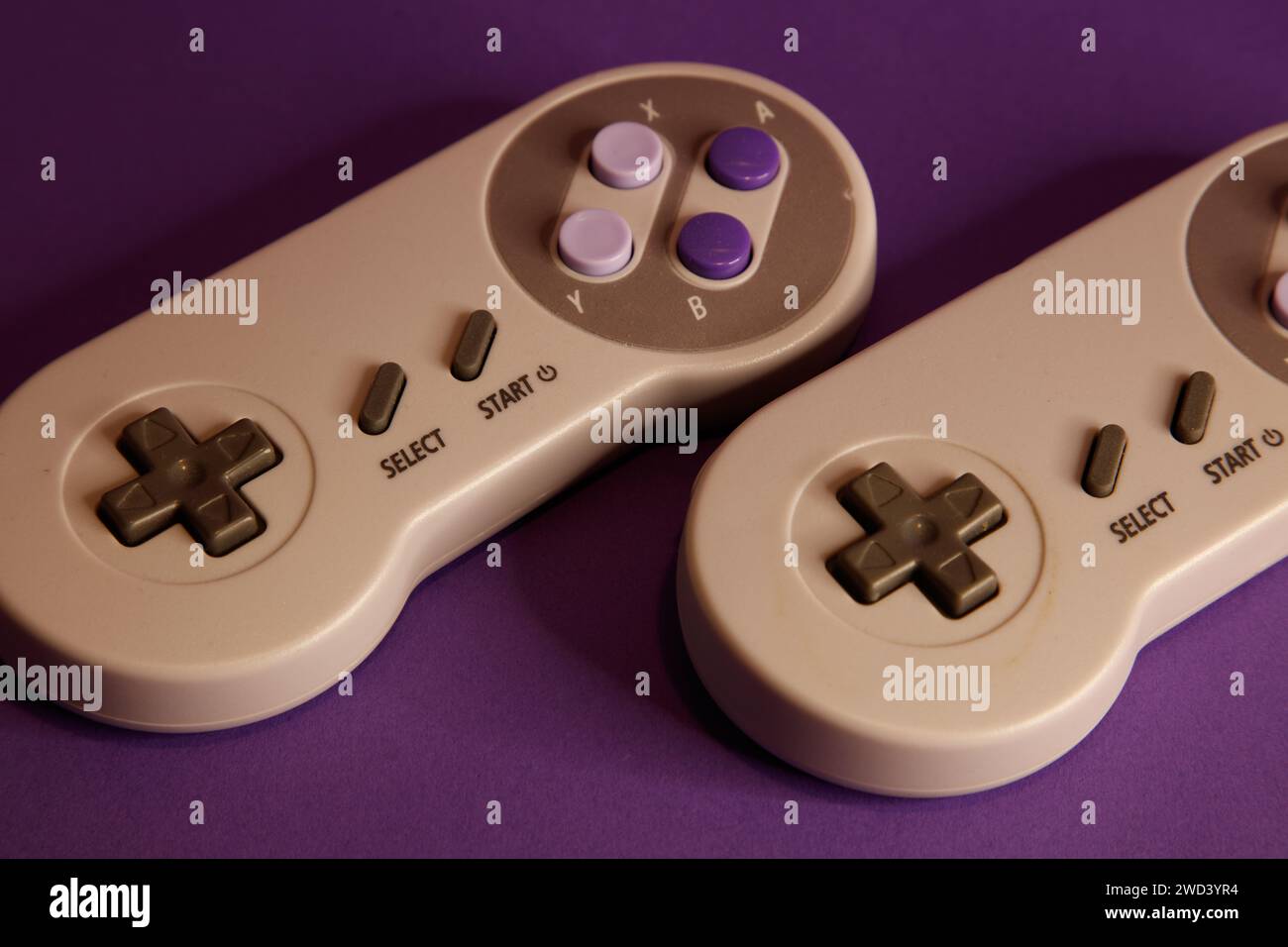 Console per videogiochi di tipo Nintendo su sfondo mouve, fotografia in studio Foto Stock