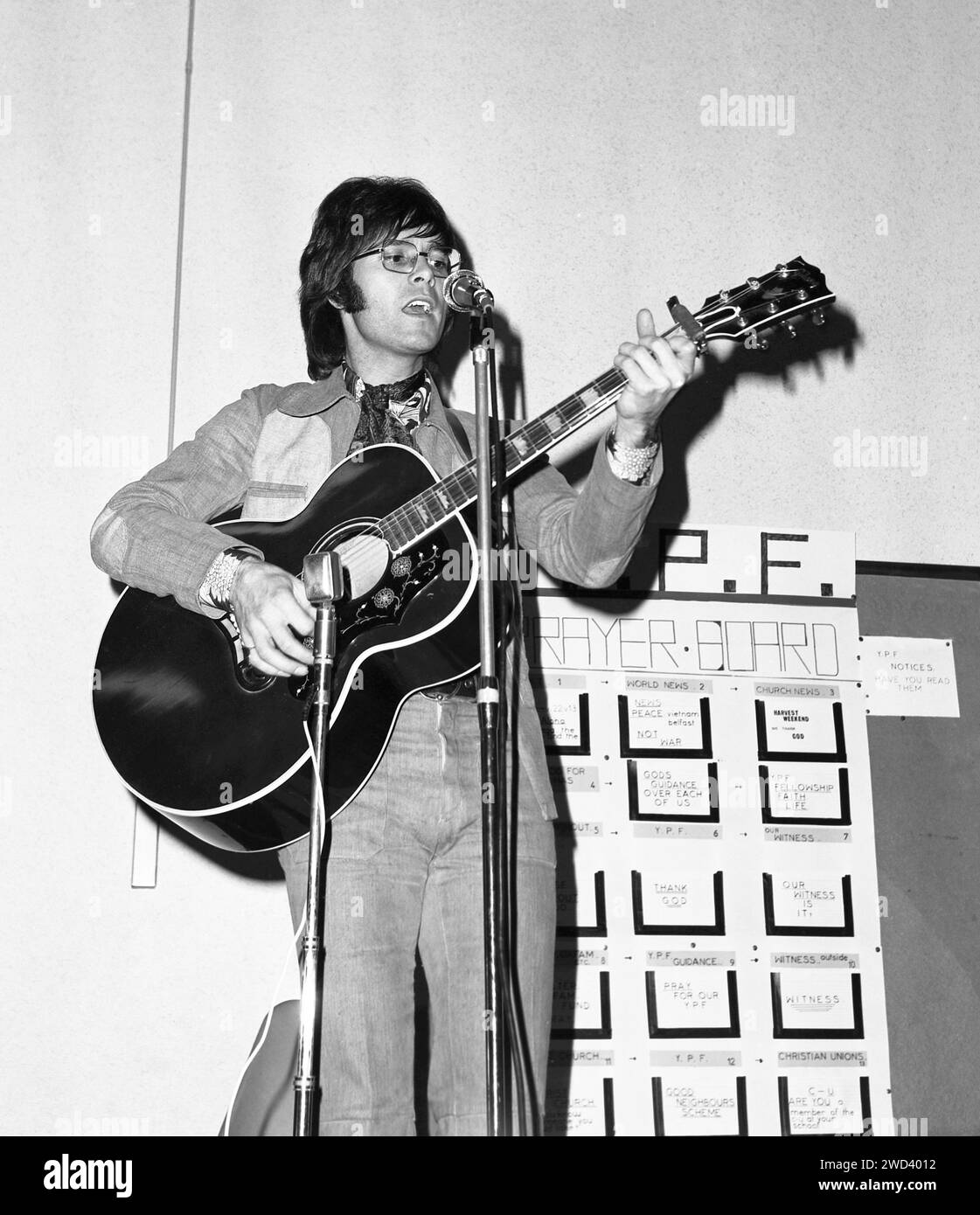 Cliff Richard che suona la chitarra e canta in un evento di beneficenza in una sala della chiesa, 1971 Foto Stock